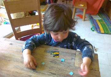 Kind puzzelt eine zerschnittene FAHRKARTE